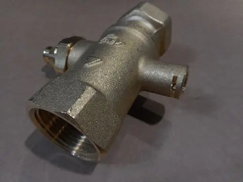 Solarkugelhahn von Remeha, made of brass, with multiple connection points for fluid handling, resting on einer neutralen Fläche.